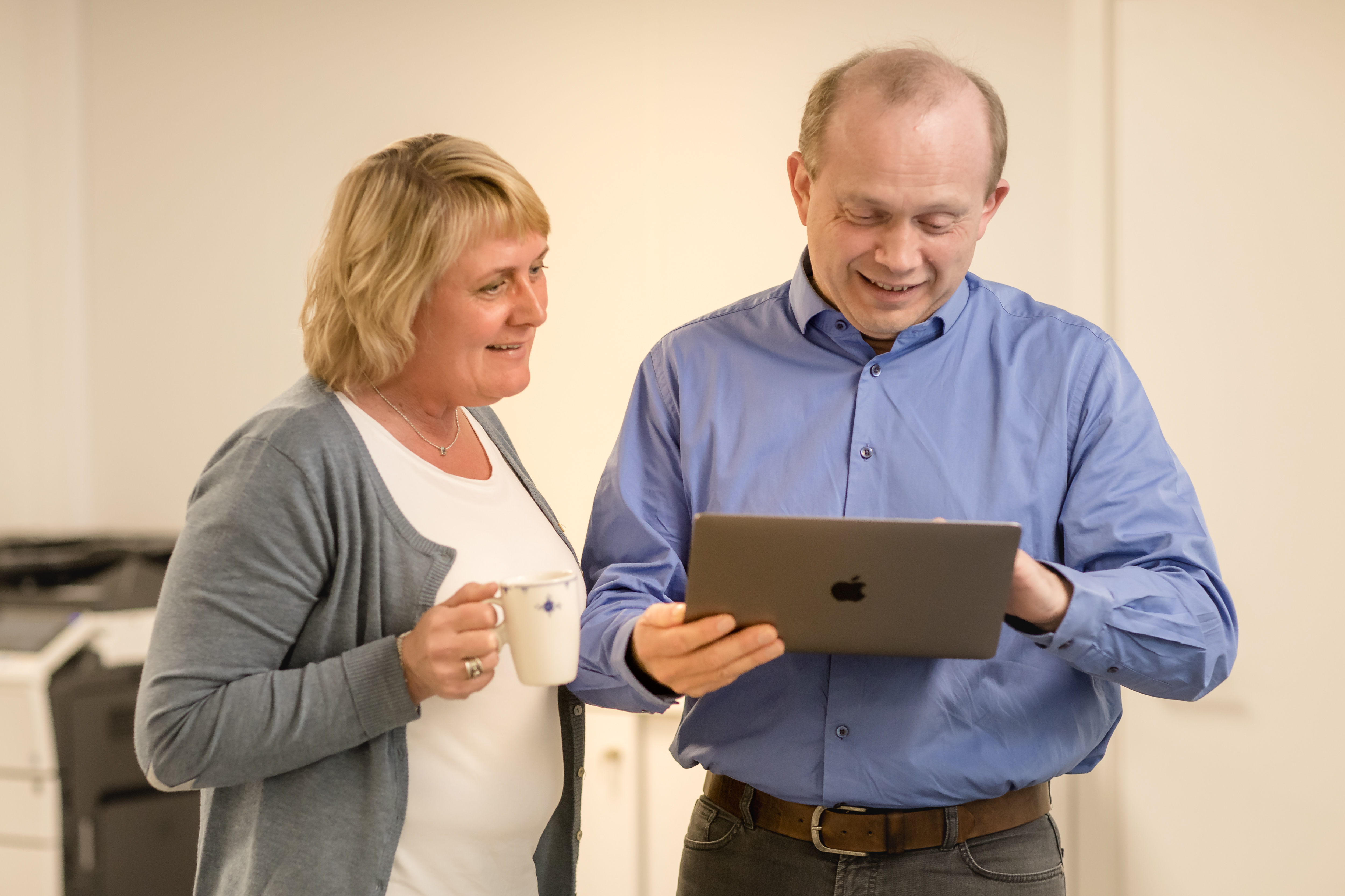 To ansatte i Vestmar Regnskap som ser på en iPad